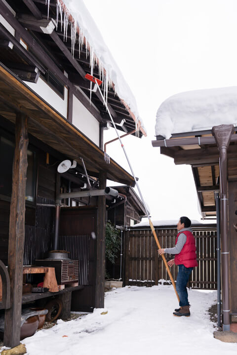 A man cracks icicles