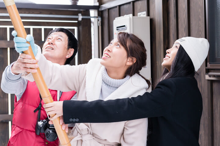 Girls trying to crack icicles