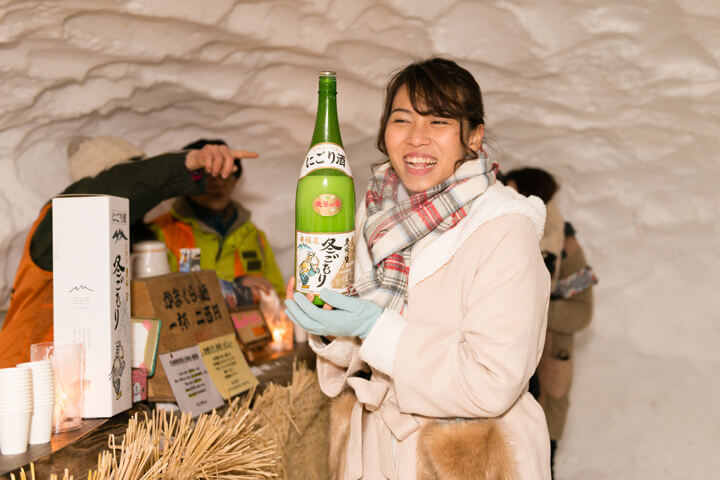 A happy girl with sake in the snow dome